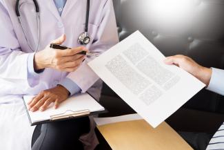 midsection-doctor-with-patient-holding-paper-hospital.jpg